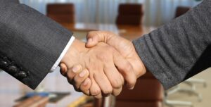 two people shaking hands: fiduciary duty